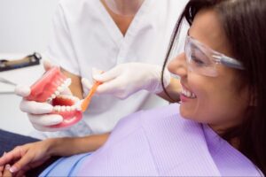dentist showing patient model of teeth