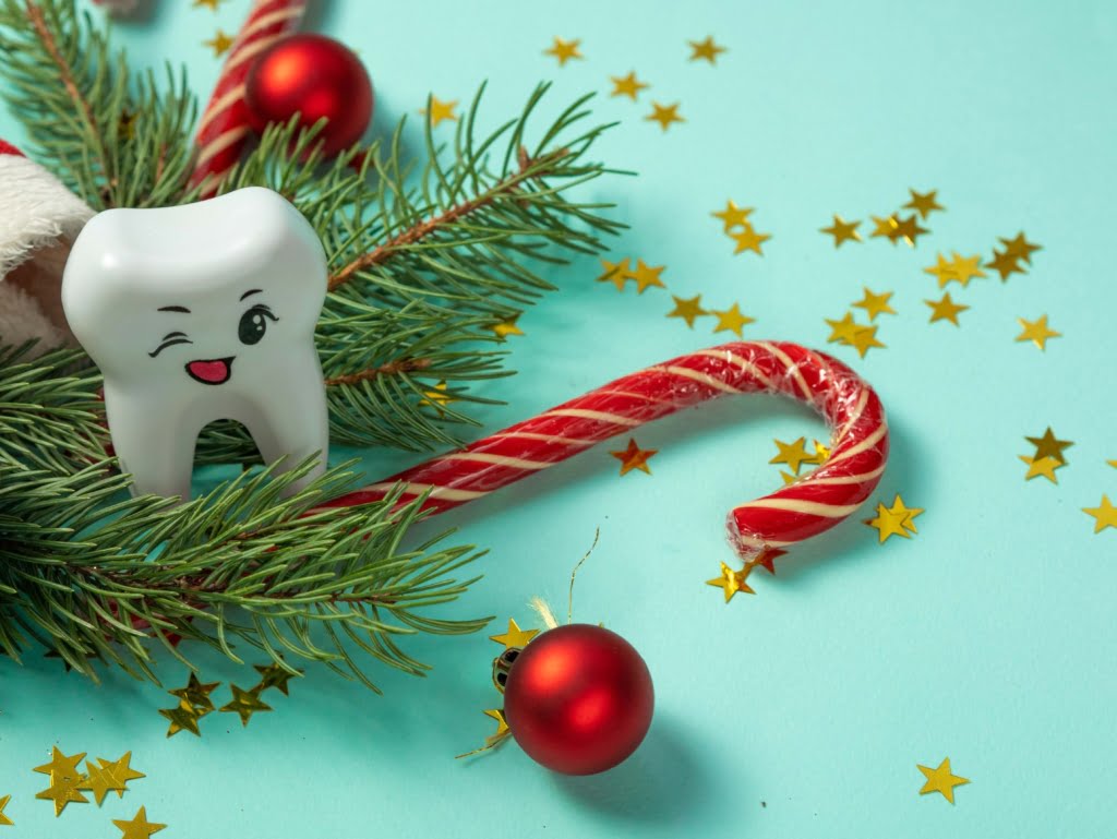large tooth winking with christmas decorations in background 